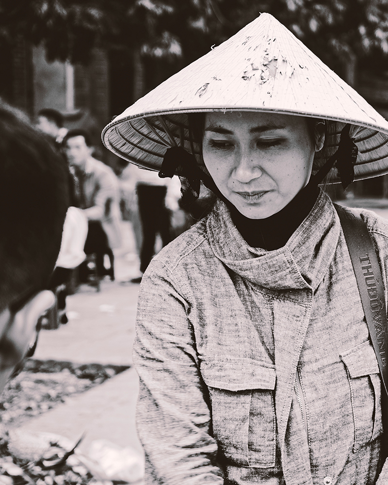 Vendor on the street in traditional Vietnamese hat