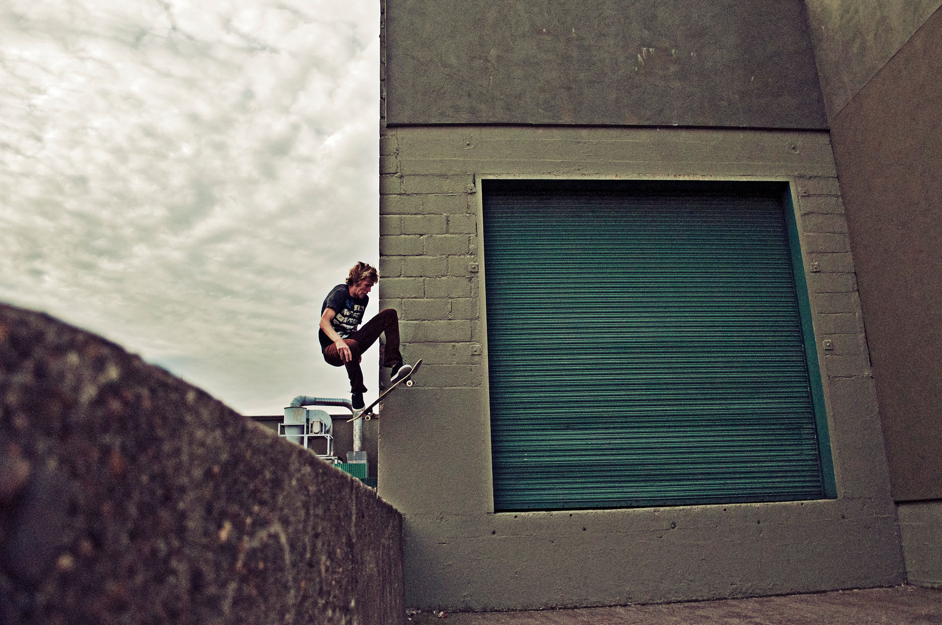Skateboarder doing trick into loading dock